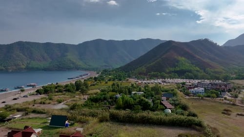 Picturesque View of a Coastline Town Nestled Amongst Lush Greenery with Boats Dotting the Water and