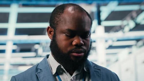Man with Tablet Inspecting Servers in Data Center
