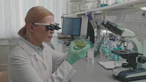 Female Scientist Examining Plant Sample on Petri Dish