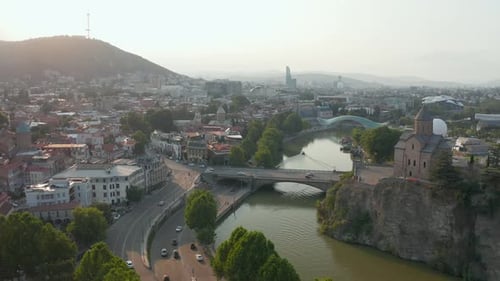Aerial view of downtown Tbilisi, Georgia at sunset, sunrise with mountains in the background. Backwa