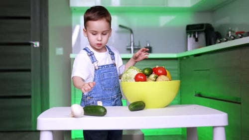 Young Boy Playing with Vegetables in Kitchen