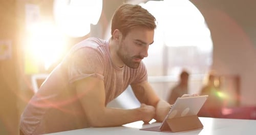 Jeune homme adulte travaillant sur tablette numérique