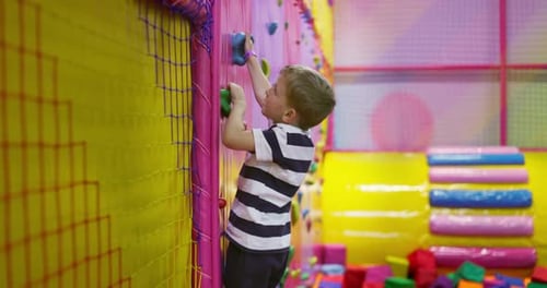 Child Climbing in Colorful Indoor Playground