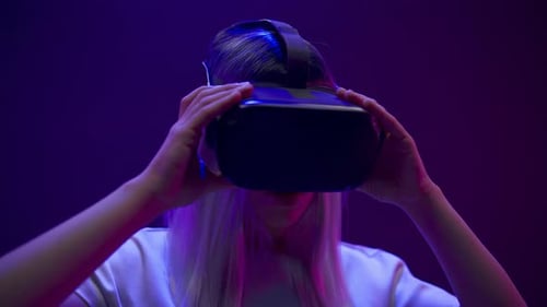 Woman Removing VR Headset in a Futuristic Setting