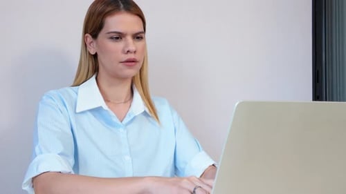 Woman Working at a Laptop at a Desk