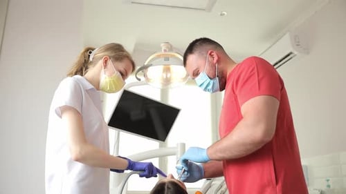 Dentists Treat a Patient's Teeth in a Dental Office Work in the Clinic