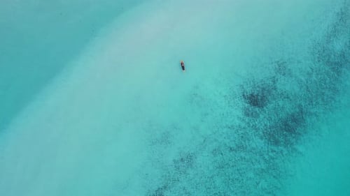 stand up paddling sub in Turquoise crystal clear water. Buttery soft aerial view flight vertical bir