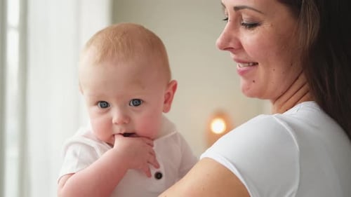 Mother Cuddles Cute Baby, Indoor Portrait