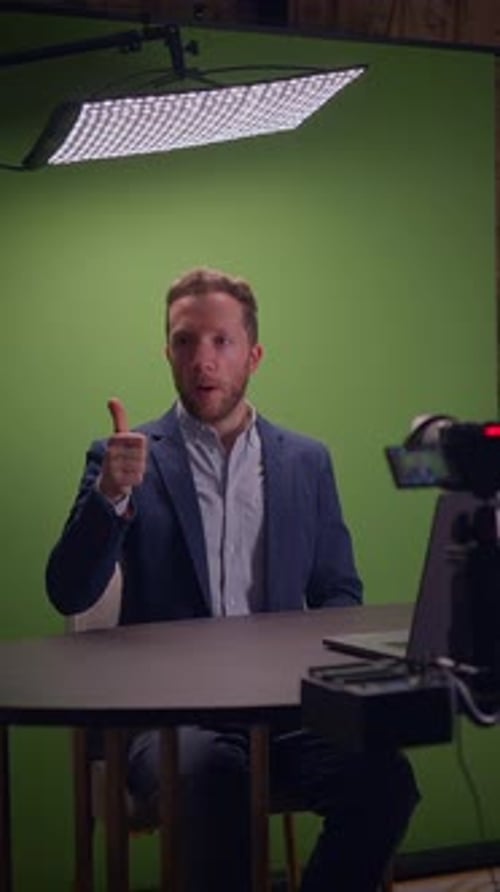 A Professional Man Engaged in a Virtual Meeting Setup While Utilizing a Green Screen