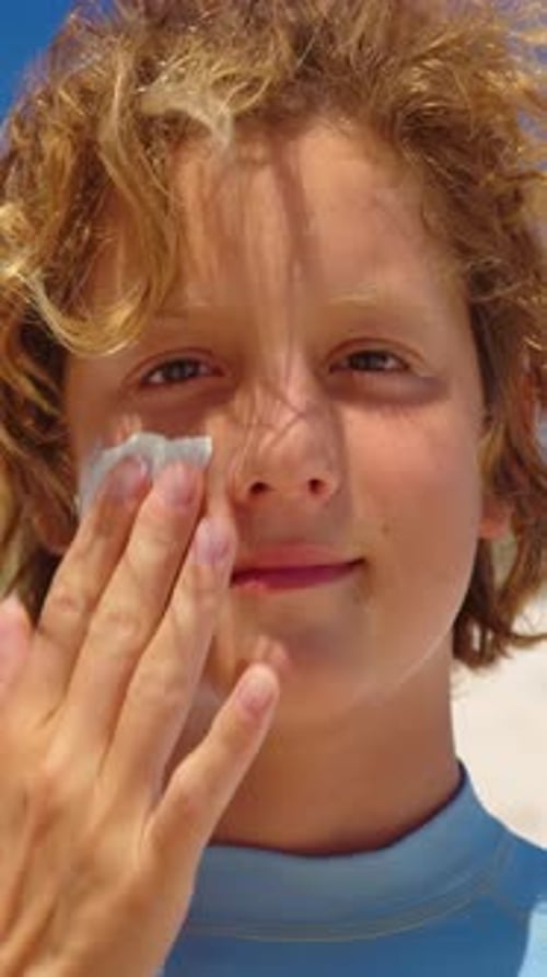 Vertical Video Mom Boy Applies Sun Cream on Face and Boy Enjoys the Sun