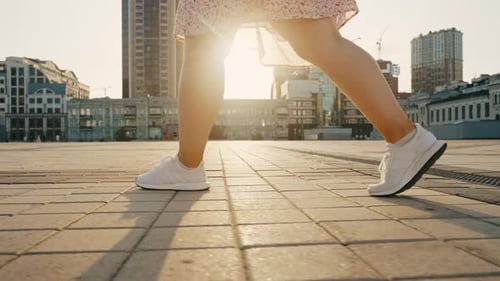 Closeup of the Girl's Legs Starting to Move Along the Street