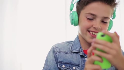 Smiling Boy Listening to Music with Teal Headphones