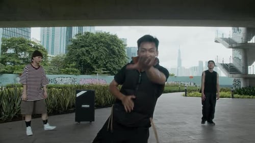 Guy Breakdancing to Camera in Urban Park with Friends