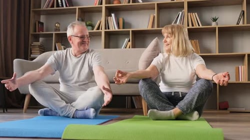 Senior Couple Practicing Yoga Together at Home