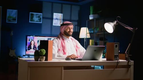 Man Working on Laptop in Home Office at Night