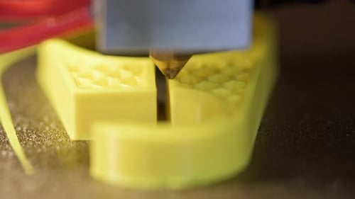 3D Printer Printing a Part Made of Yellow Plastic Closeup View