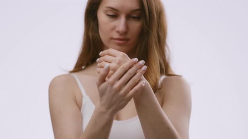 Woman Applies Moisturizing Cream to Hands