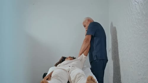 Physical Therapist Massaging Woman on Examination Table