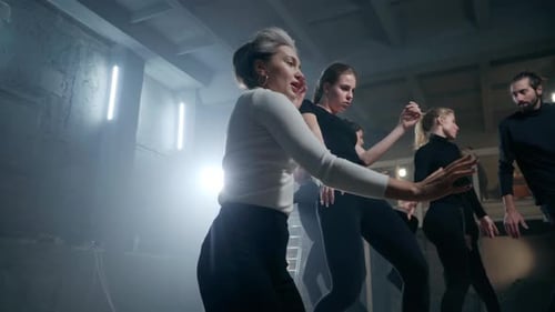 Slim Gorgeous Talented Theater Director Showing Movements to Actors and Actresses on Stage Talking