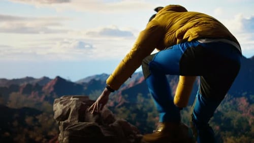 Male Hiker Looks Out Over a Breathtaking Mountain Range From the Hill Top