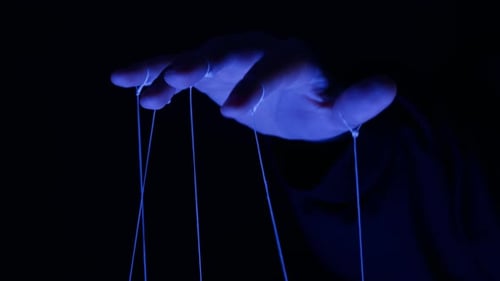 The Puppeteer Controls the Puppets in the Theater in Blue Neon Light Closeup Managing People at Work