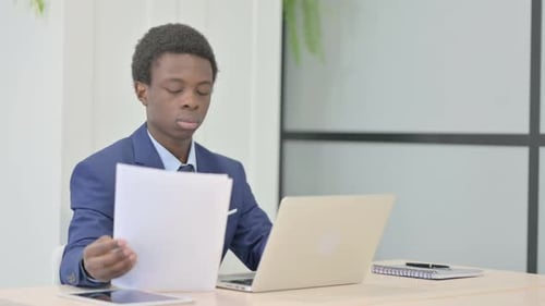 Young Adult Working With Documents at Desk