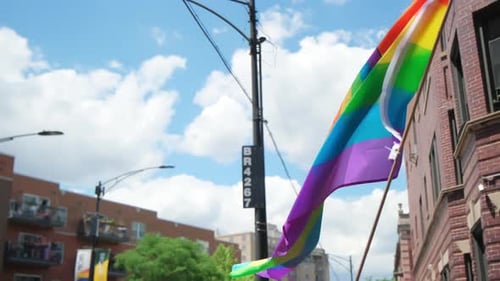 Pride Flag Waving in the Breeze on City Street
