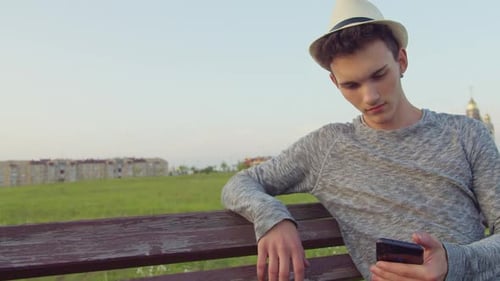 Young Adult Using Cell Phone in Park