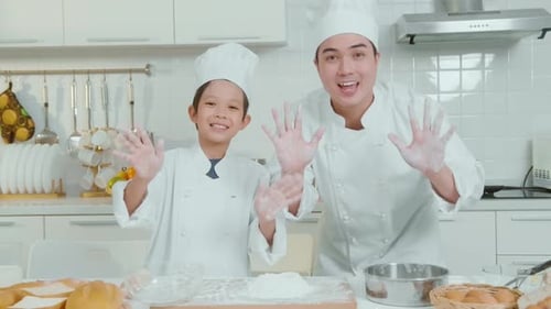 Father and Child Baking and Waving in Kitchen