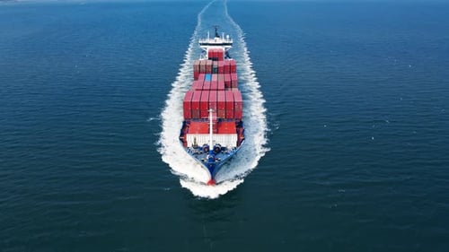 Cargo Ship Sailing Through Ocean with Red Containers