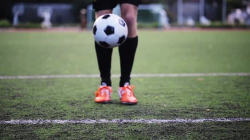 Man Balancing Soccer Ball on Feet Outdoors