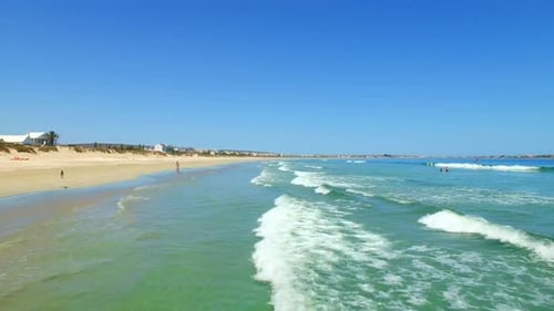 Aerial drone, beach and water waves on ocean coast, sand or neighborhood with buildings near shore