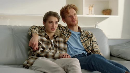 Couple Relaxing on Couch Watching Television Together