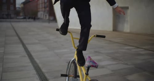 Man in Suit Balances on Bicycle in City