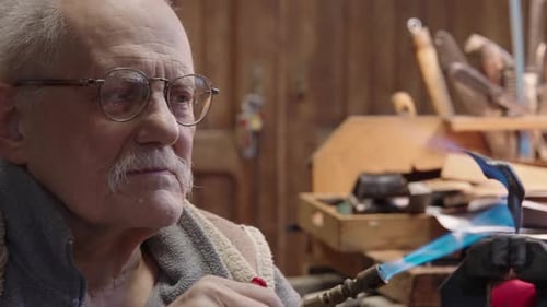 Senior Elderly Master Jeweler in Wheelchair Works in a Workshop
