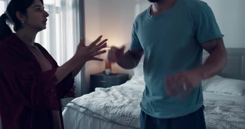 Couple Arguing and Gesturing in Bright Bedroom