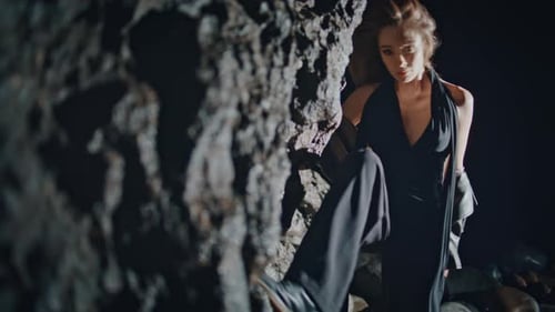 Glamorous Woman Posing in Dark Rocky Setting