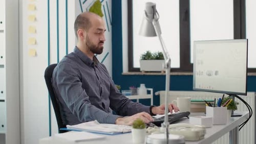 Young Adult Working on Computer at Modern Office