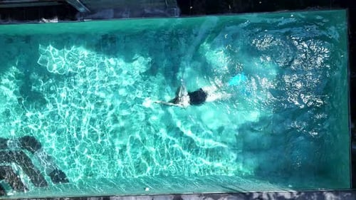 A Top View of a Swimmer in a Clear Blue Swimming Pool with Flippers Enjoying a Leisurely in Bali