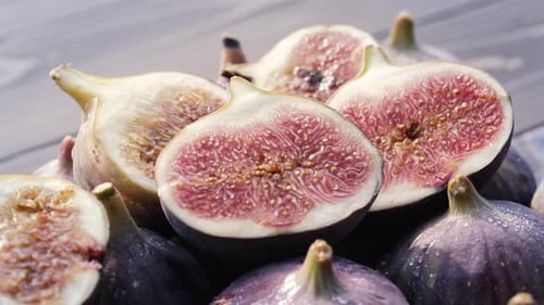Ganze, zarte, frische, reife Feigen mit Blüten und Wassertropfen Ficus Carica, Seitenansicht, gesunde Ästhetik