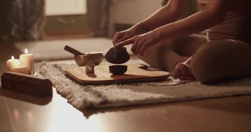 Woman Pours Tea on Rug with Candles