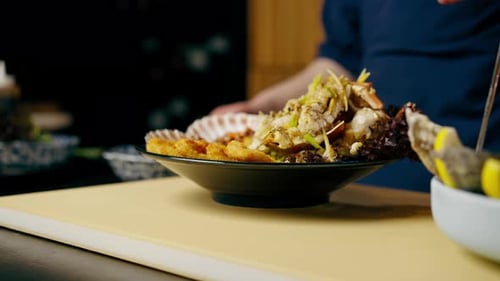 Closeup in a Japanese Restaurant Chef in Blue Prepares an Expensive Plate of Seafood