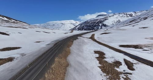 Aerial view of snow-covered mountains and road, Iceland.
