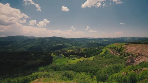 Forested Mountains With Rolling Clouds On A Sunny Day. Timelapse