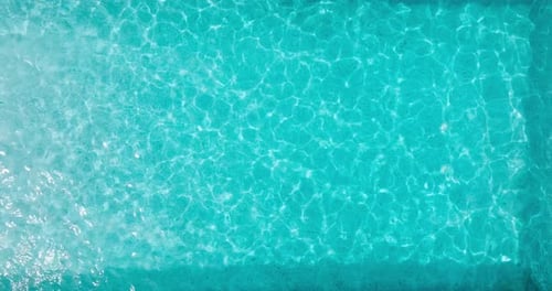 Blue Water in the Swimming Pool with Light Reflections
