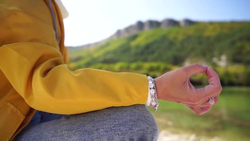 Woman Meditating by Scenic Lakeside in Mountain Setting