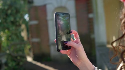 Woman Holds Smartphone in Urban Setting