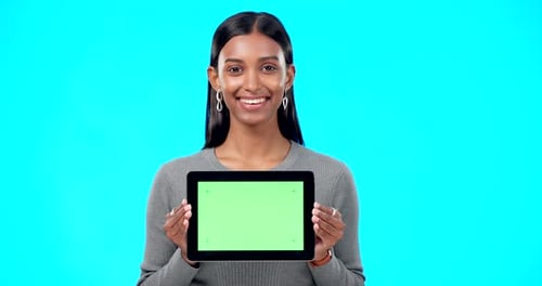 Space, green screen and face of a woman with a tablet isolated on a blue background in a studio