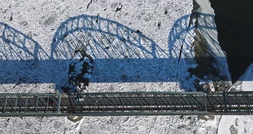 Traffic on bridge over a frozen river with ice floes.
