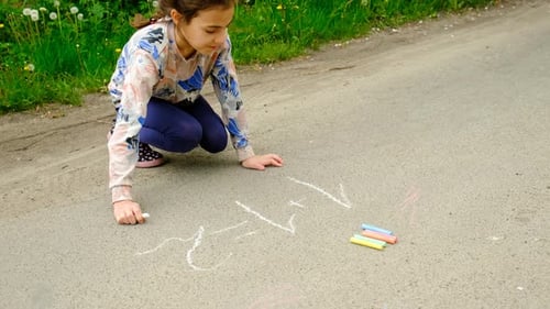 un niño escribe ejemplos matemáticos en el enfoque selectivo de asfalto